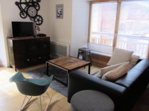 a living room with a couch and a table at Résidence Olympiades - Olympiades A11 MAE-9051 in Gourville