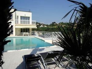 a swimming pool with chairs and a house at Villa Alamp#supercannes #golfejuan #cannes #Mediterraneanpanoramicview #piscine #rooftop # verymodern #openliving #closebeach #closecapantibes in Vallauris