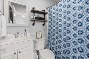 a bathroom with a toilet and a blue and white shower curtain at Piece of Heaven in New Braunfels +30 photos