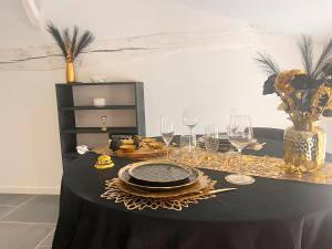 a table with a black table cloth with glasses and a vase at Love Room Luxure 50 Nuances in Jonzac