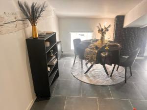 a dining room with a black table and chairs at Love Room Luxure 50 Nuances in Jonzac +9 photos