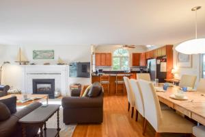 Una cocina y una sala de estar con mesa y sillas. en Outdoor entertaining re-imagined Enjoy a new luxury back yard, en Eastham