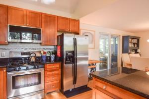 Una cocina con electrodomésticos de acero inoxidable y gabinetes de madera. en Outdoor entertaining re-imagined Enjoy a new luxury back yard, en Eastham