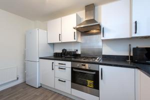 a kitchen with white cabinets and a stove top oven at Tudhoe View - 3 bed 2 bath house in Spennymoor