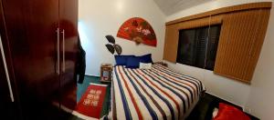 a small bedroom with a bed with a striped blanket at Casa em Villagio na Riviera in Riviera de São Lourenço