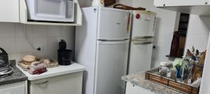 a kitchen with two refrigerators and a microwave at Casa em Villagio na Riviera in Riviera de São Lourenço