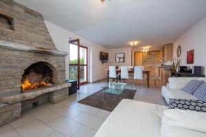 salon z dużym kamiennym kominkiem w obiekcie Villa Aquila w mieście Pianello Del Lario