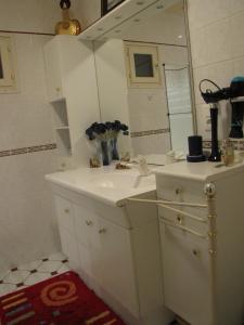 a white bathroom with a sink and a mirror at Les Moinillons Piscine toute l'année mini 30 degrés l'hiver in Ancy-le-Franc