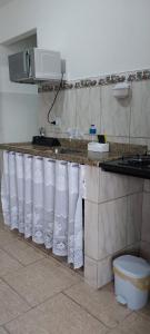 a kitchen with a counter with white towels on it at Verde Mar Abricó 2 in Rio das Ostras