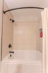 a white bath tub with a shower curtain in a bathroom at Creekside Hideaway -Oak Bay, NB in Oak Haven