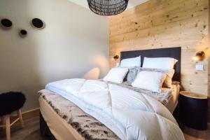 a bedroom with a large bed with a wooden wall at Chalet Gaspesie - CHALET GASPESIE MAE-6991 in Les Avanchers