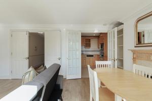 a dining room and kitchen with a table and chairs at Two bed Two bath Kensington Apartment in London +11 photos