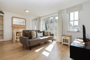 a living room with a couch and some windows at Two bed Two bath Kensington Apartment in London