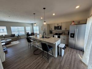 a kitchen and living room with a refrigerator and a table at The HoneyBee at Coventry Rows in Omaha