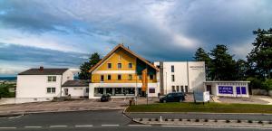 ein gelbes und weißes Gebäude an der Straßenseite in der Unterkunft Amethysthotel Mantler in Maissau