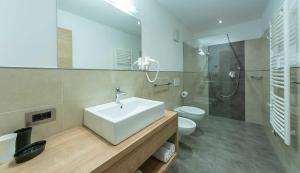 un bagno con lavandino, WC e doccia di Costadedoi a San Cassiano Altre 59 foto
