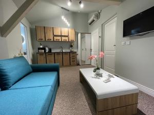 a living room with a blue couch and a table at Fantasia Apart Hotel in Bucharest