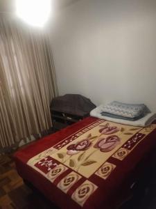un letto in una stanza con una coperta sopra di Apartamento de praia a Capão da Canoa