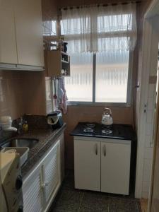 una piccola cucina con lavello e fornello di Apartamento de praia a Capão da Canoa