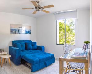 a blue couch in a living room with a ceiling fan at Coco Paraiso Baranquilla - Hermosos Apartamentos Cercanos Al Malecón Del Rio in Barranquilla