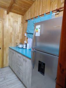 a refrigerator in a kitchen with a blue counter at Acogedora Casa en Frutillar in Frutillar +6 photos