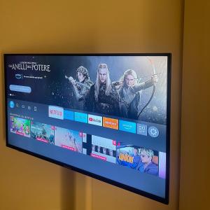 a television with a movie on the screen at La Suite del Maestro in Bienno +2 photos