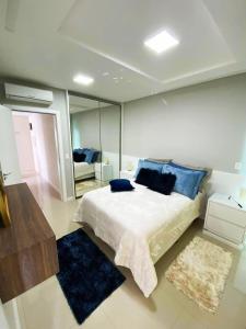 a bedroom with a large bed and a mirror at Apto 350 metros do mar com 2 garagens e ar condicionado in Meia Praia