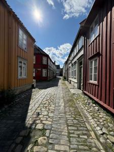 a cobblestone street in a town with wooden buildings at Koselig studioleilighet i sentrum in Trondheim