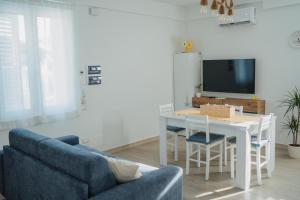 a living room with a table and a blue couch at Casa degli Ulivi - Apartment B in Porto San Giorgio