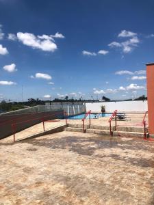 a swimming pool next to a body of water at Flat Red Sorocaba- Green in Sorocaba