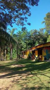 a house in the middle of a yard with trees at Chalé no Sana - Conforto e Aconchego in Sana +14 photos