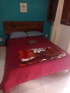 a bed with a red blanket on top of it at Chalé no Sana - Equilíbrio e Descanso in Sana