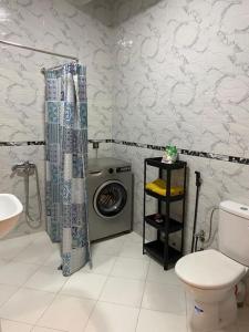 a bathroom with a toilet and a washing machine at apartamento la fontana 2 in Charf +26 photos