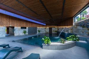 a swimming pool with a fountain in a building at Refúgio de luxo com spa, piscina interior e exterior - Pedra Aguda Spa in Fornos de Maceira Dão
