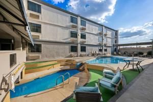 an apartment building with a swimming pool and patio furniture at SureStay Plus Hotel by Best Western Lubbock Medical Center in Lubbock