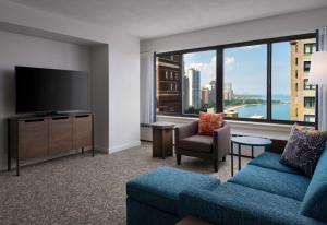 a living room with a blue couch and a large window at Sonesta ES Suites Chicago Downtown Magnificent Mile Medical in Chicago