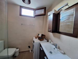 a bathroom with a sink and a toilet at Gold King Apartment in Áyios Vasílios