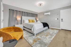 ein Schlafzimmer mit einem Bett, einer Couch und einem Sessel in der Unterkunft NEWLY BUILT SMV Oceanview Terrace House in Jacksonville Beach