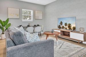 ein Wohnzimmer mit Sofa und Tisch in der Unterkunft NEWLY BUILT SMV Oceanview Terrace House in Jacksonville Beach