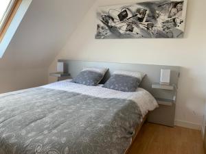 a bedroom with a bed and a painting on the wall at Jolie maison de vacances in Concarneau +28 photos