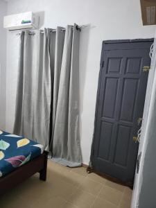 eine Tür in einem Zimmer mit Vorhängen und einem Bett in der Unterkunft Résidence Bon Séjour in Abidjan