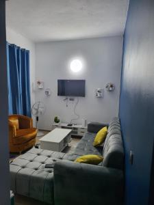 ein Wohnzimmer mit Sofa und Fernseher in der Unterkunft Résidence Bon Séjour in Abidjan