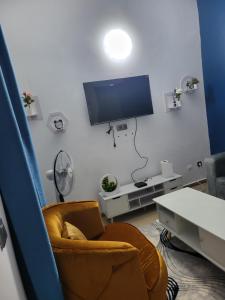 ein Wohnzimmer mit Sofa und Flachbildfernseher in der Unterkunft Résidence Bon Séjour in Abidjan
