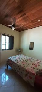 a bedroom with a bed with a comforter on it at Casa do Amaral 2 in Angra dos Reis