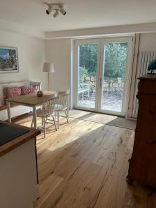 シュタルンベルクにあるWohnung mit Terrasse am Waldrandのリビングルーム(テーブル付)、ダイニングルーム(ガラスのスライドドア付)