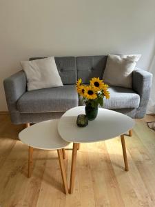 a living room with a couch and a table with flowers at Wohnung mit Terrasse am Waldrand in Starnberg