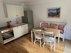 シュタルンベルクにあるWohnung mit Terrasse am Waldrandのテーブルと椅子のあるキッチンとダイニングルーム