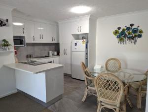 a kitchen with a table and a white refrigerator at Bay Lodge Apartments in Gold Coast
