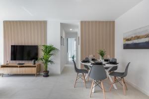 Un comedor con mesa y sillas y un televisor. en Eleven 4, en Santa Cruz de Tenerife