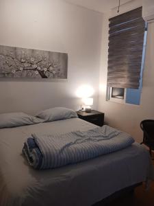 a bedroom with a bed and a table and a window at POSADA del MAR in Puerto Escondido